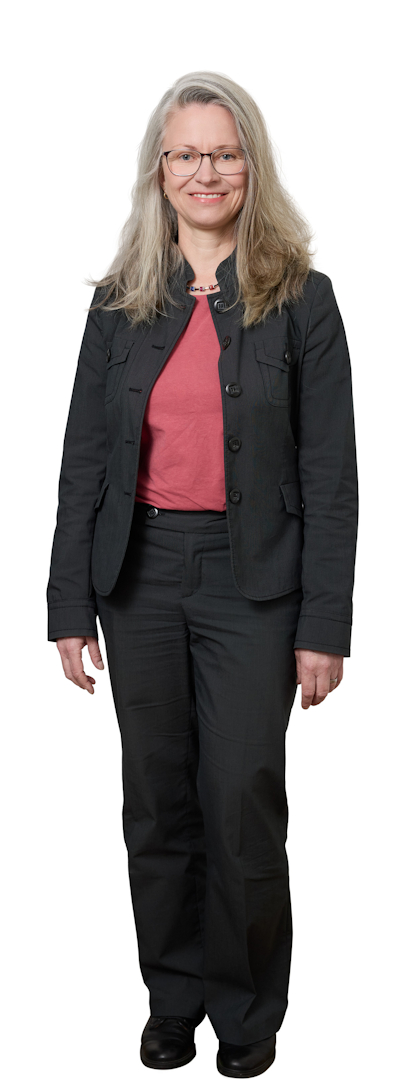 Professional woman with gray hair and glasses in a black blazer and pink top, standing against a white background.