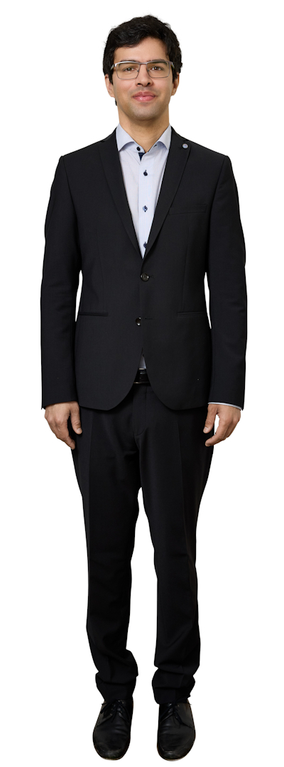 Man in a dark suit and light blue shirt standing and facing the camera.