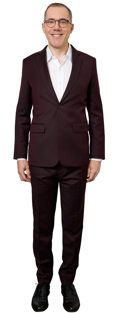 Man wearing a burgundy suit with a white shirt, standing and smiling at the camera.